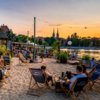 People relaxing at an urban beach bar on the Oder River in Wrocław at sunset