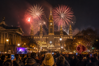 Celebrating New Year's Eve in Vienna with fireworks over the historic city center and festive crowds at midnight