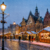 Snowy evening at the Wrocław Christmas Market in the Old Town with festive lights, wooden stalls, and the Gothic Town Hall.