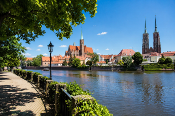 Shaded riverside promenade in Wrocław during a hot summer day near Ostrów Tumski